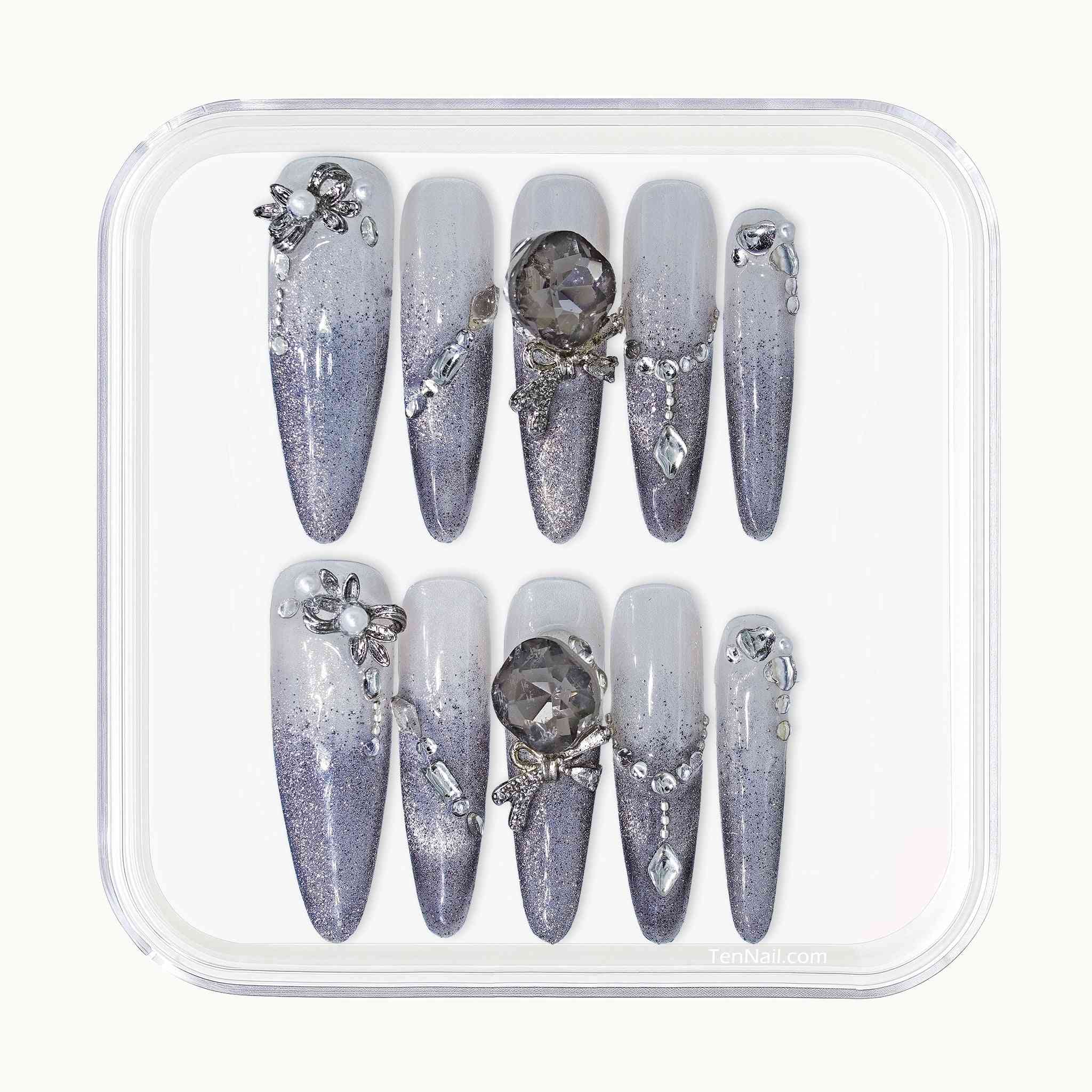 Set of decorative nails with gemstones in a clear plastic case on a white background